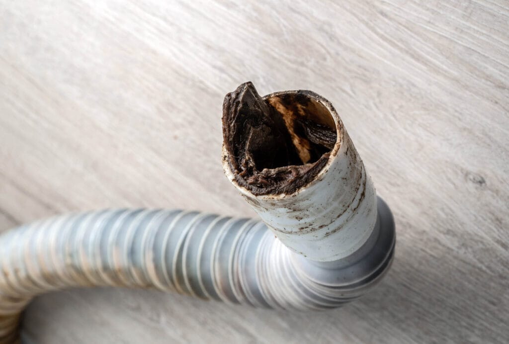 Clogged drain pipe showing severe blockage and buildup, highlighting the need for drain cleaning services and sewer line repairs by JW Plumbing Pros in Northwest Georgia.