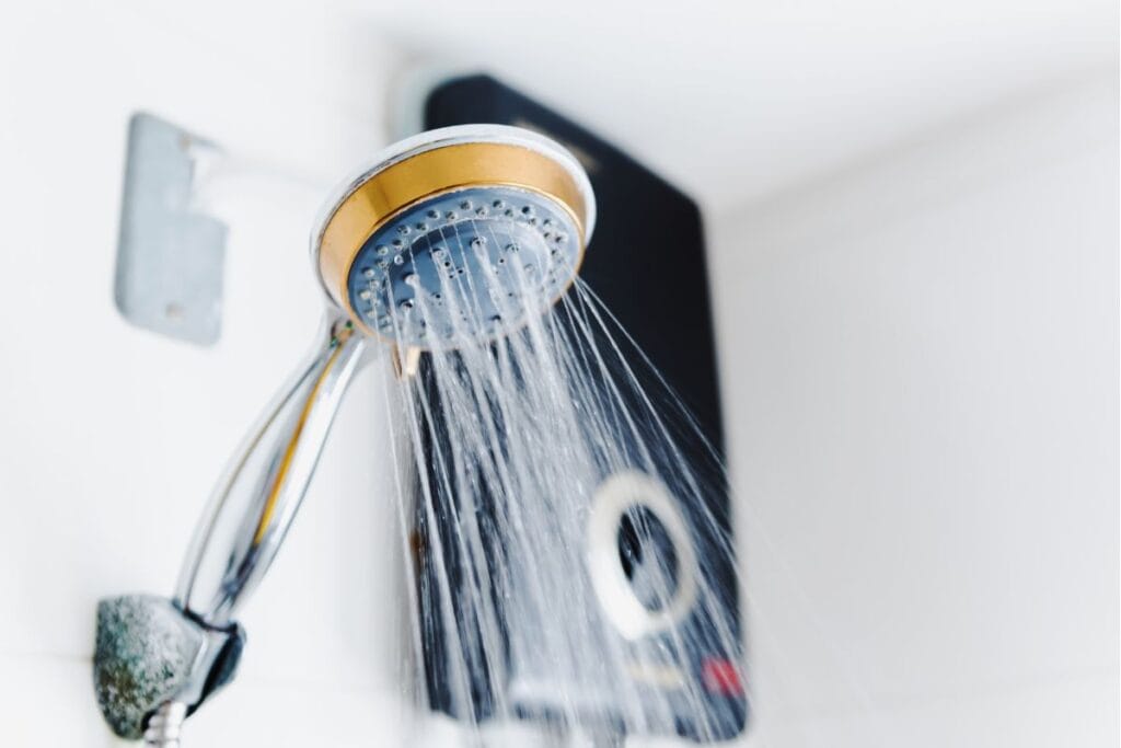 Showerhead with water flowing, highlighting modern plumbing and water heater efficiency, relevant to signs of water heater issues.