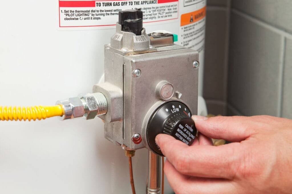 Water heater thermostat being adjusted, showcasing maintenance for efficient hot water heating.