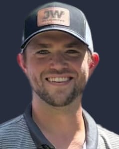 Jesse Rodgers, co-owner of JW Plumbing Pros, smiling in a branded cap, representing commitment to quality plumbing services and customer satisfaction.