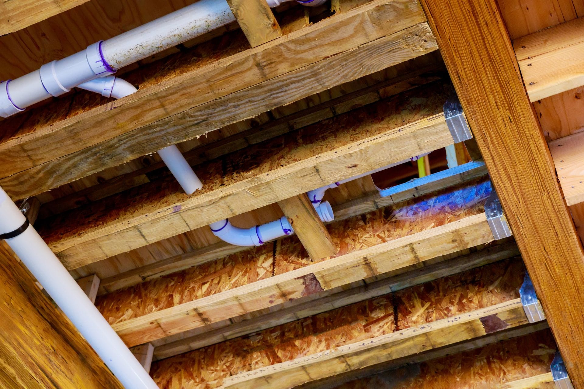 Rough-in plumbing installation showcasing PVC pipes and wooden beams in a home renovation setting, emphasizing the foundational work essential for a reliable plumbing system in Dallas, GA.