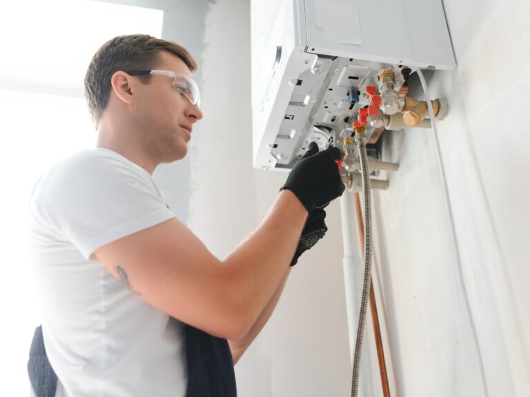 Plumber troubleshooting a water heater, adjusting valves and connections for heating issues, emphasizing home plumbing maintenance.